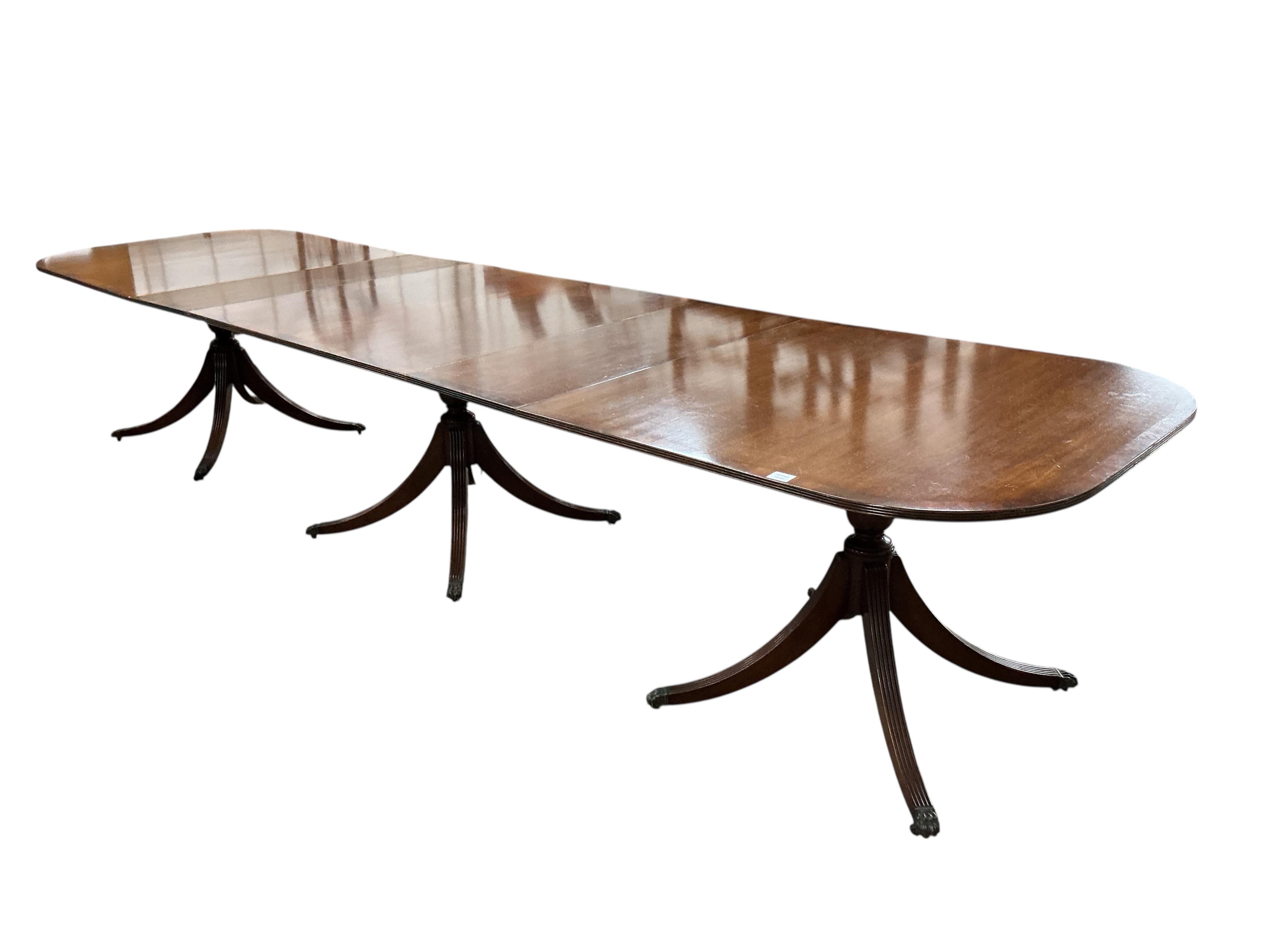 A reproduction George III style mahogany triple pillar extending dining table, width 500cm extended, two spare leaves, depth 108cm, height 75cm